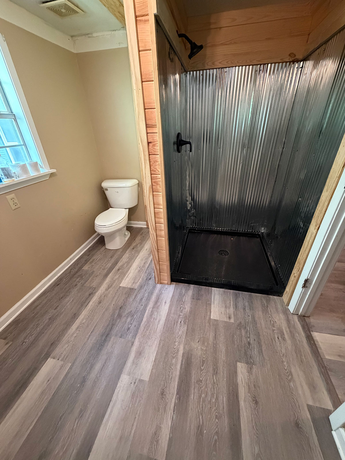 Custom walk-in shower with corrugated metal panels and wood trim