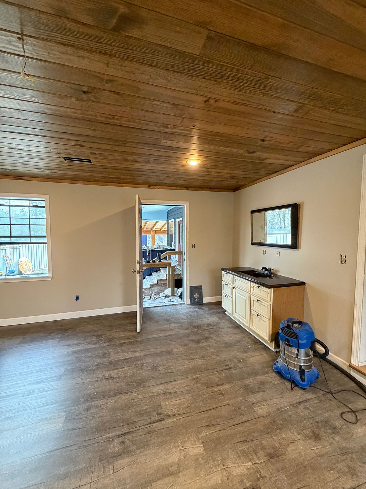Open living space with wood ceiling and fresh flooring