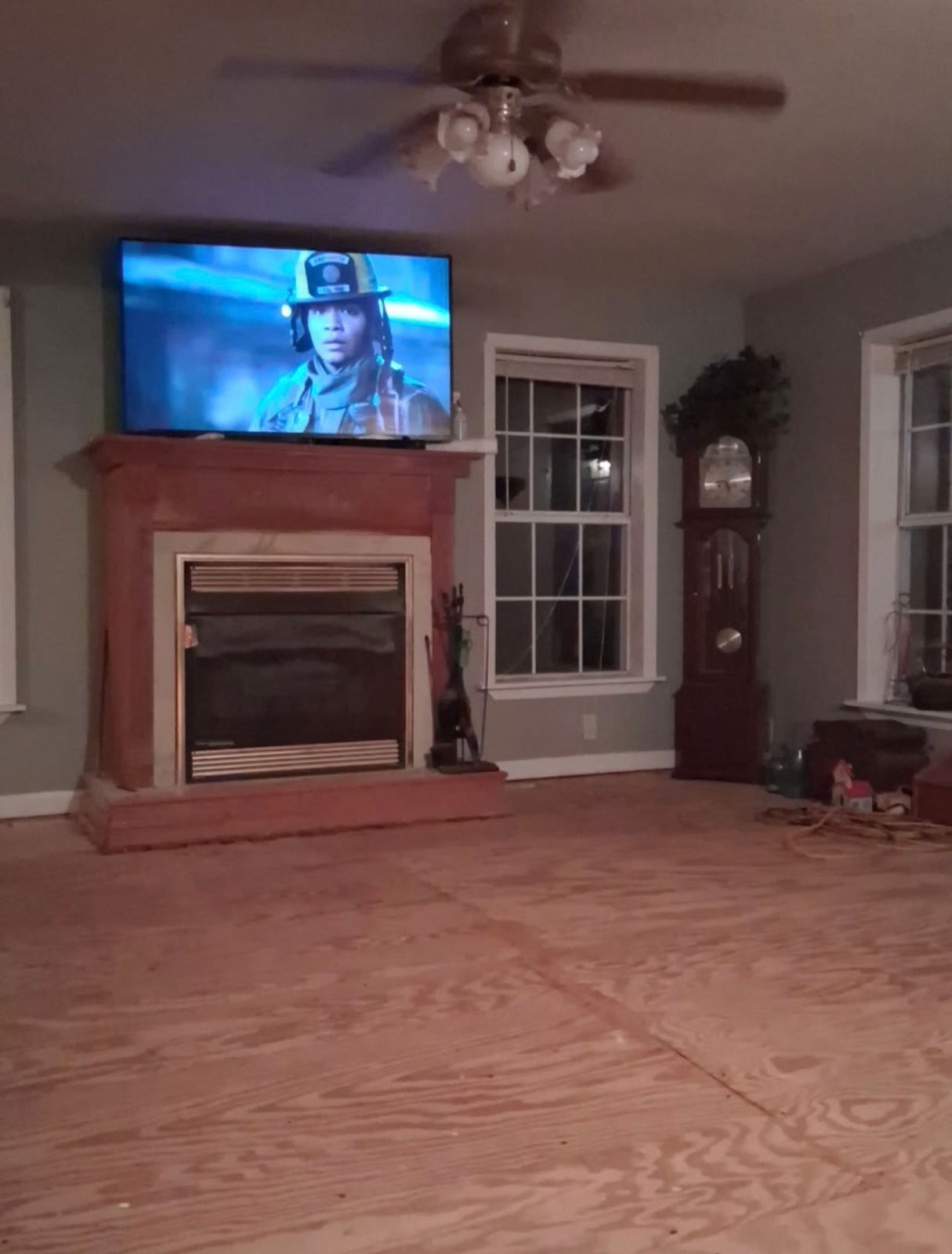 Living room with fireplace and new subfloor being installed